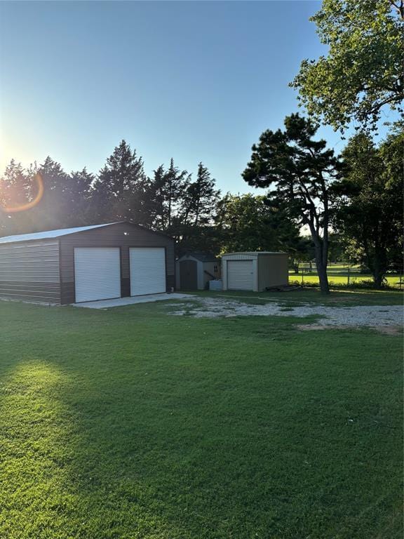 1717 S Webster Dr, Midwest City, OK 73130 - view of green lawn featuring a detached garage and a storage shed