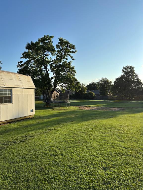1717 S Webster Dr, Midwest City, OK 73130 - view of green lawn with a trampoline and a shed