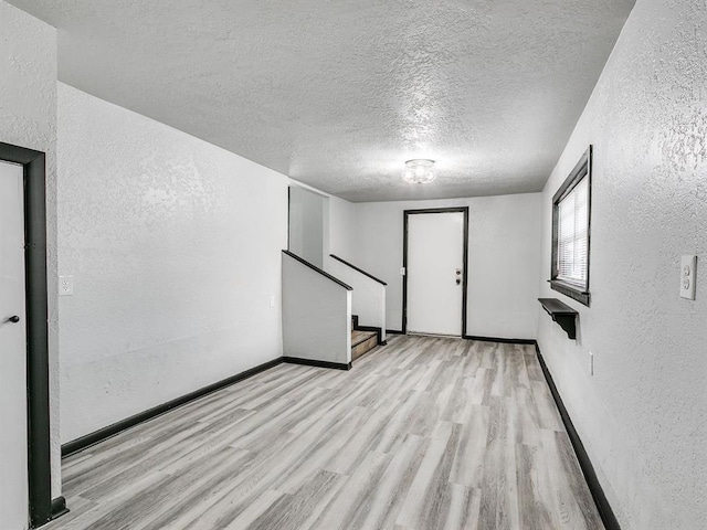 3225 SE 20th St, Oklahoma City, OK 73115 - spare room with a textured wall, wood finished floors, a textured ceiling, and stairway