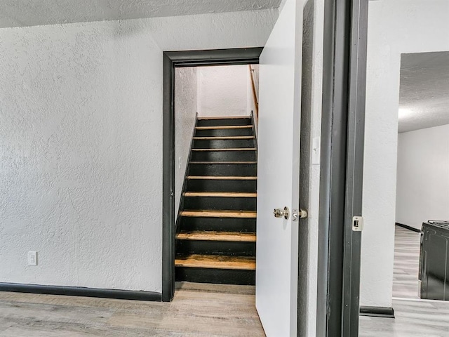3225 SE 20th St, Oklahoma City, OK 73115 - stairway featuring a textured wall, wood finished floors, and a textured ceiling