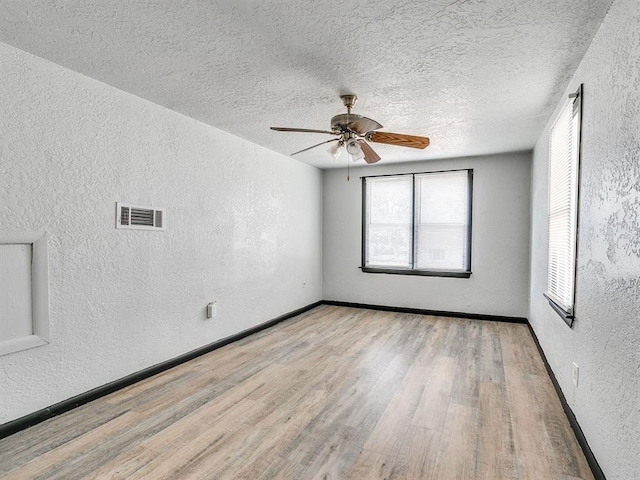 3225 SE 20th St, Oklahoma City, OK 73115 - unfurnished room with a textured wall, wood finished floors, a ceiling fan, and a textured ceiling
