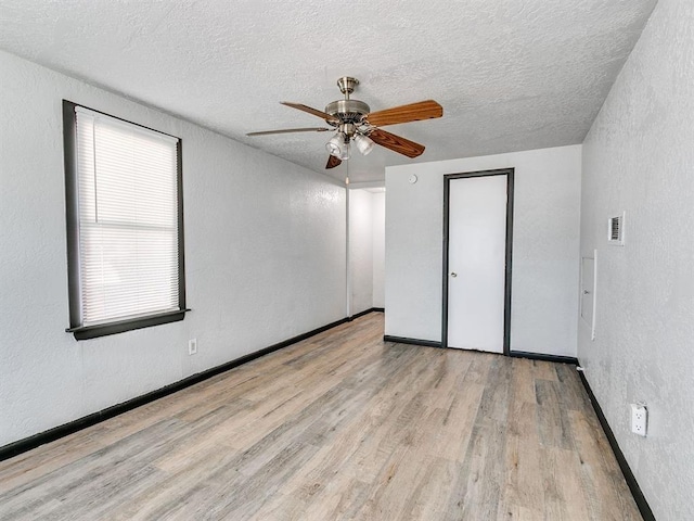 3225 SE 20th St, Oklahoma City, OK 73115 - unfurnished bedroom with wood finished floors, a textured ceiling, a textured wall, and ceiling fan