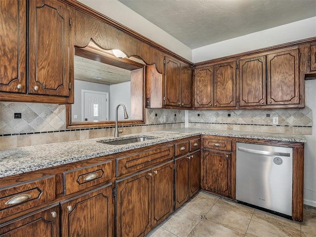 201 N Base Ave, Norman, OK 73069 - kitchen featuring stainless steel dishwasher, decorative backsplash, light stone counters, and light tile patterned floors