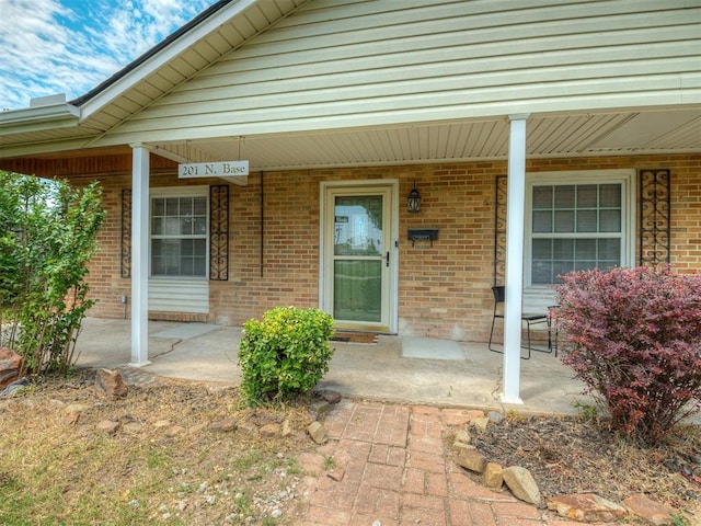 201 N Base Ave, Norman, OK 73069 - view of exterior entry featuring covered porch and brick siding