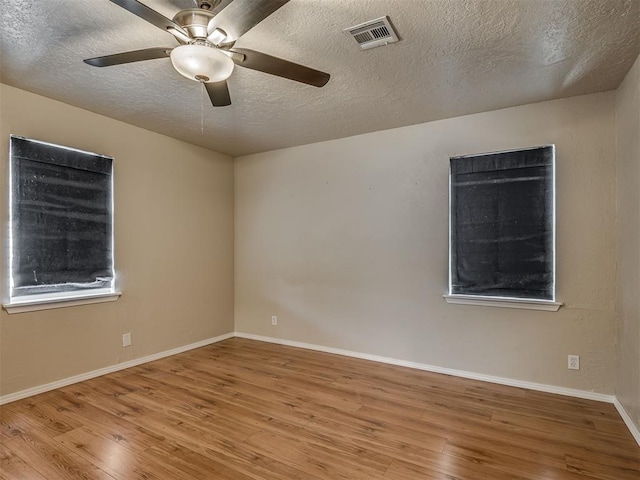 201 N Base Ave, Norman, OK 73069 - spare room featuring wood finished floors, a ceiling fan, and a textured ceiling