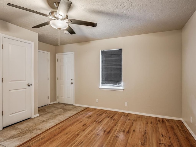 201 N Base Ave, Norman, OK 73069 - empty room with wood finished floors, a ceiling fan, and a textured ceiling