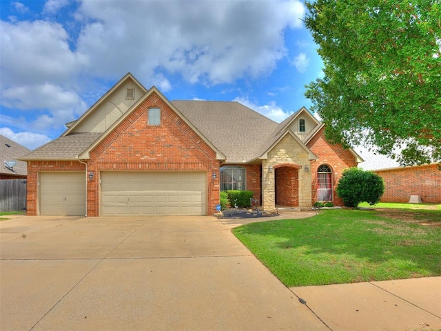1621 NW 182nd St, Edmond, OK 73012 - traditional home with concrete driveway, an attached garage, a front yard, brick siding, and stone siding