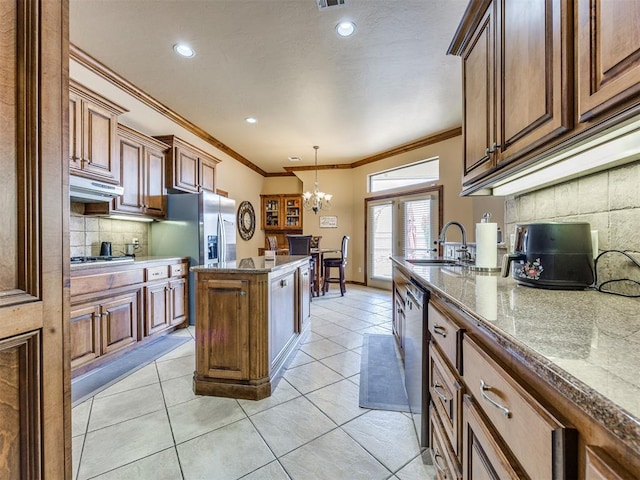 1621 NW 182nd St, Edmond, OK 73012 - kitchen with a chandelier, decorative backsplash, under cabinet range hood, crown molding, and a kitchen island