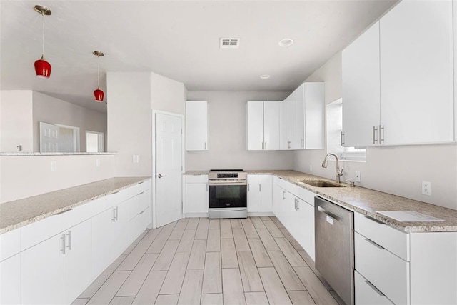 27919 Tortola Ln, Blanchard, OK 73010 - kitchen with appliances with stainless steel finishes, white cabinetry, pendant lighting, light wood finished floors, and recessed lighting