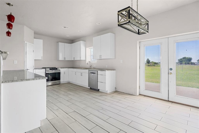 27919 Tortola Ln, Blanchard, OK 73010 - kitchen featuring appliances with stainless steel finishes, french doors, stone counters, white cabinetry, and pendant lighting