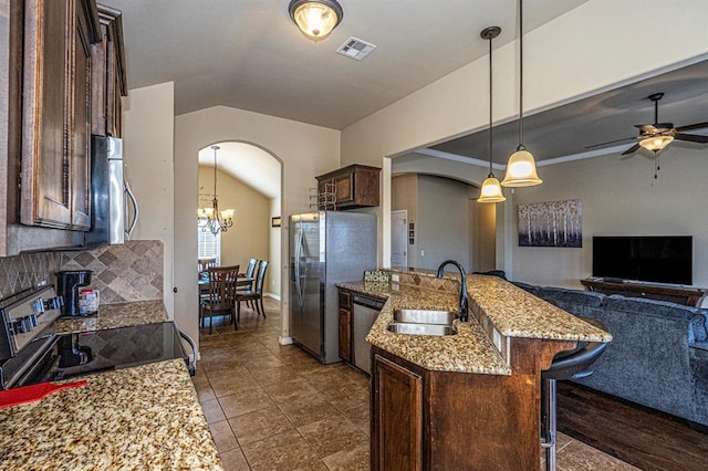 1613 NW 124th St, Oklahoma City, OK 73120 - kitchen featuring appliances with stainless steel finishes, arched walkways, lofted ceiling, open floor plan, and dark brown cabinets