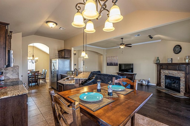 1613 NW 124th St, Oklahoma City, OK 73120 - dining space featuring lofted ceiling, arched walkways, a chandelier, ceiling fan, and a fireplace