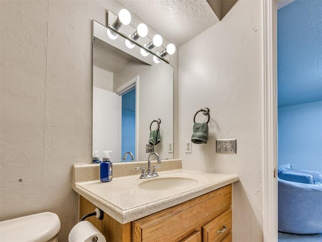 14313 N Pennsylvania Ave Unit 7E, Oklahoma City, OK 73134 - half bathroom with vanity, a textured wall, and a textured ceiling