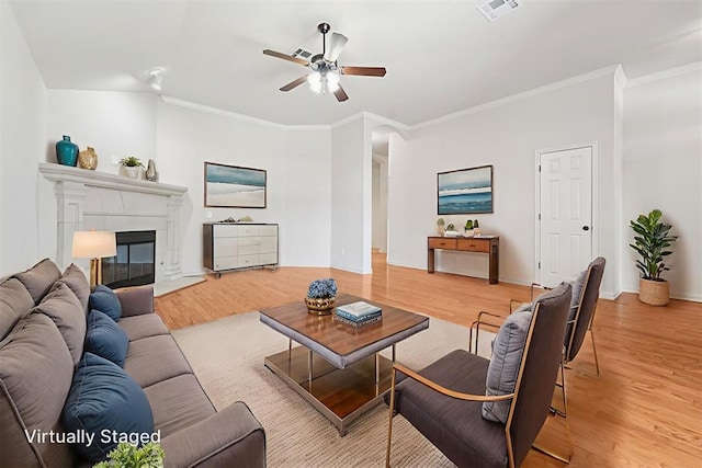 9716 SW 21st Ter, Oklahoma City, OK 73128 - living room with ceiling fan, light wood-style floors, crown molding, and a glass covered fireplace