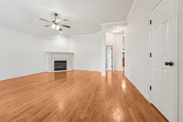 9716 SW 21st Ter, Oklahoma City, OK 73128 - unfurnished living room with ceiling fan, arched walkways, light wood-style floors, ornamental molding, and a fireplace with flush hearth