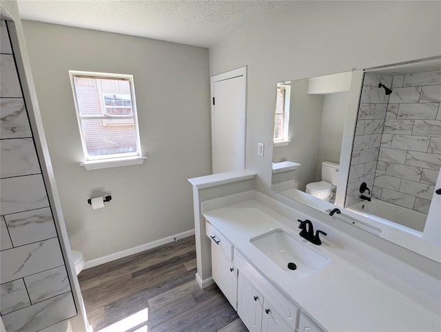 104 SW 10th St, Moore, OK 73160 - bathroom with plenty of natural light, vanity, wood finished floors, tub / shower combination, and a textured ceiling