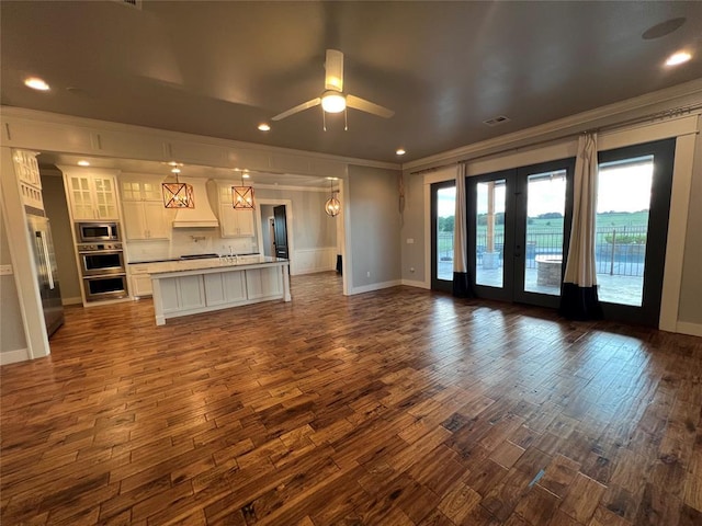 17566 N County Road 3190, Pauls Valley, OK 73075 - unfurnished living room featuring crown molding, dark wood-style floors, french doors, ceiling fan, and recessed lighting