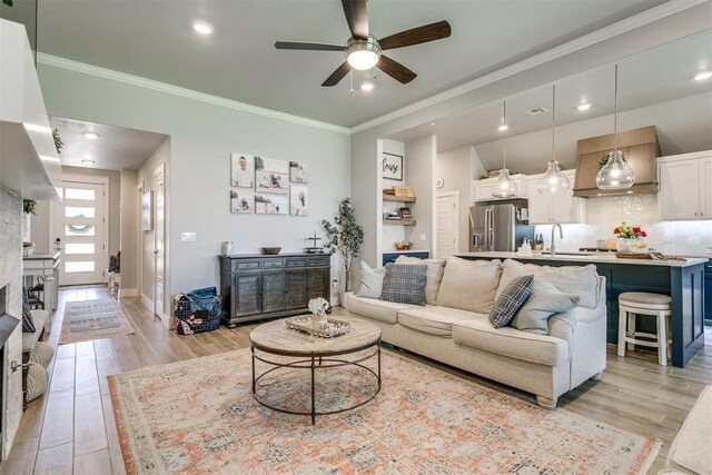 10125 NW 99th St, Yukon, OK 73099 - living area featuring light wood-style floors, a ceiling fan, crown molding, and recessed lighting