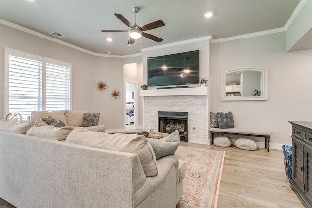 10125 NW 99th St, Yukon, OK 73099 - living area featuring a stone fireplace, light wood-style flooring, ceiling fan, ornamental molding, and recessed lighting
