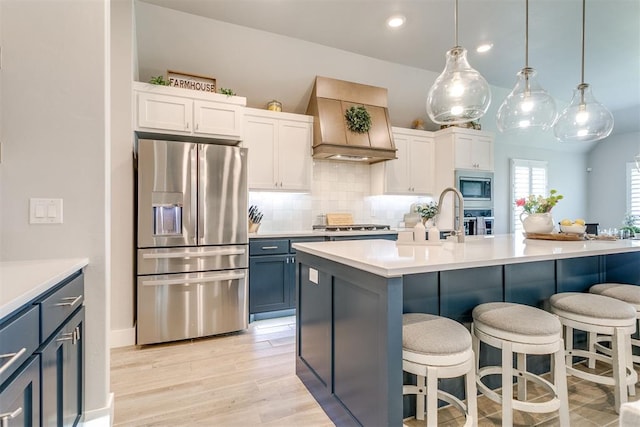 10125 NW 99th St, Yukon, OK 73099 - kitchen with appliances with stainless steel finishes, custom exhaust hood, backsplash, a kitchen bar, and light countertops