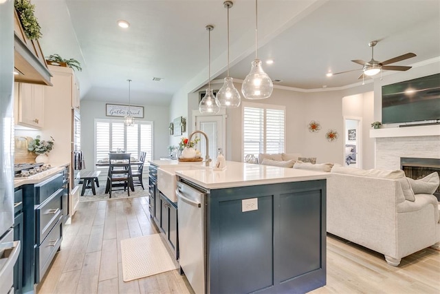 10125 NW 99th St, Yukon, OK 73099 - kitchen with stainless steel dishwasher, open floor plan, light wood-type flooring, light countertops, and recessed lighting