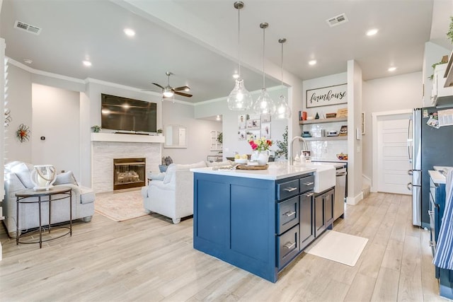 10125 NW 99th St, Yukon, OK 73099 - kitchen featuring stainless steel appliances, a ceiling fan, crown molding, light countertops, and light wood finished floors