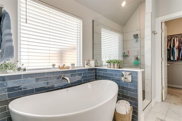 10125 NW 99th St, Yukon, OK 73099 - bathroom with a freestanding bath, marble look tile flooring, a walk in closet, tiled shower, and lofted ceiling