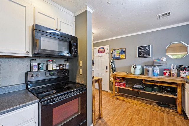 807 Thompson Dr, El Reno, OK 73036 - kitchen with black appliances, ornamental molding, light wood-style flooring, white cabinets, and tasteful backsplash