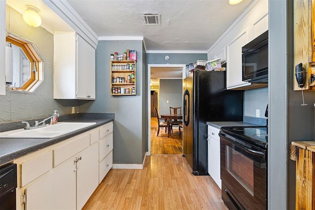 807 Thompson Dr, El Reno, OK 73036 - kitchen featuring black appliances, white cabinetry, light wood-style flooring, dark countertops, and ornamental molding