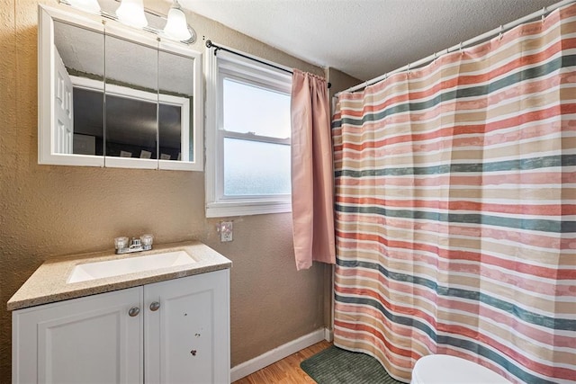 807 Thompson Dr, El Reno, OK 73036 - full bath featuring a textured wall, a textured ceiling, wood finished floors, vanity, and a shower with shower curtain
