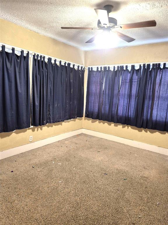 4300 N Butler Pl, Oklahoma City, OK 73118 - empty room with a textured ceiling, a ceiling fan, and carpet floors