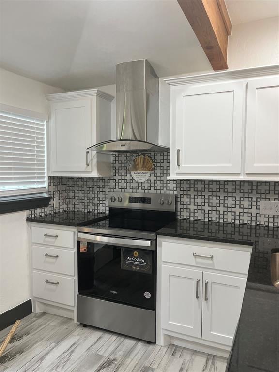 2416 S Shartel Ave, Oklahoma City, OK 73109 - kitchen with stainless steel range with electric cooktop, wall chimney exhaust hood, dark countertops, and white cabinets