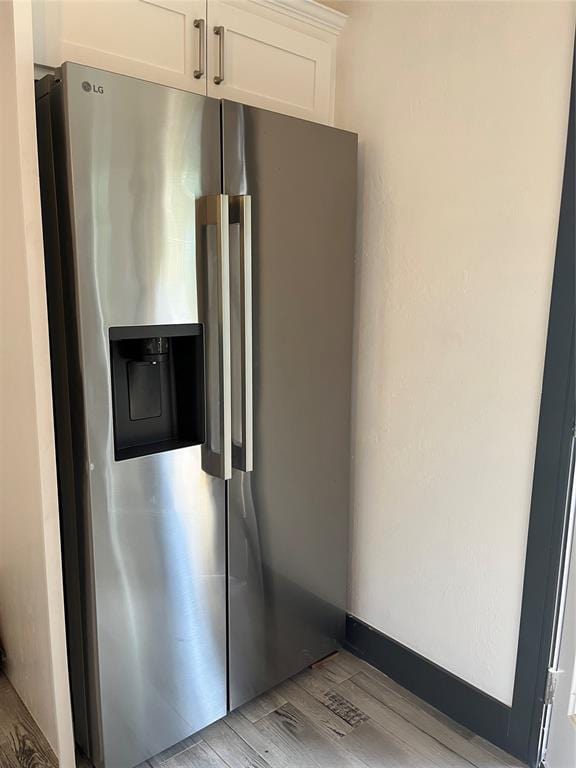 2416 S Shartel Ave, Oklahoma City, OK 73109 - kitchen with stainless steel refrigerator with ice dispenser, light wood-style flooring, and white cabinetry