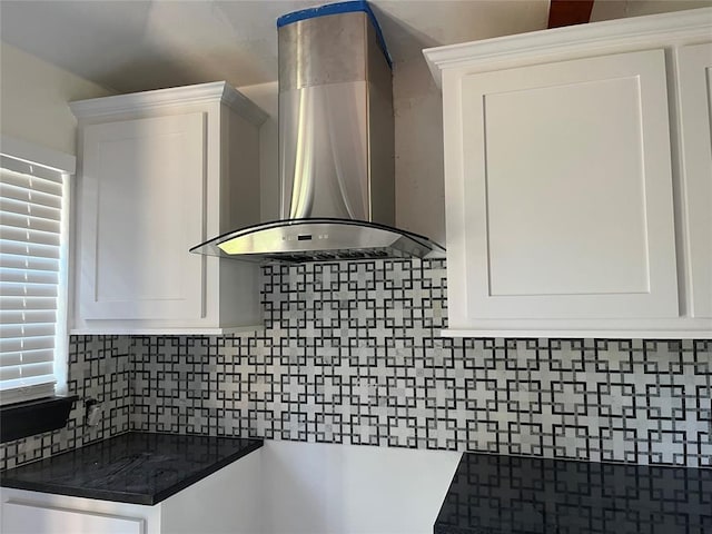 2416 S Shartel Ave, Oklahoma City, OK 73109 - kitchen with wall chimney range hood, white cabinets, backsplash, and dark countertops