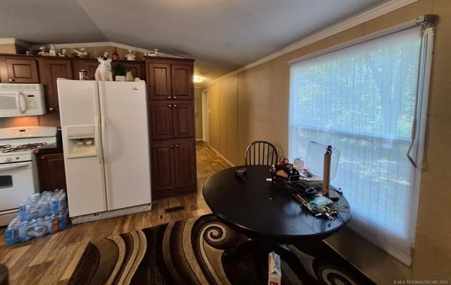 2908 Harber Loop Dr, Grove, OK 74344 - kitchen with white appliances, light wood finished floors, lofted ceiling, and crown molding