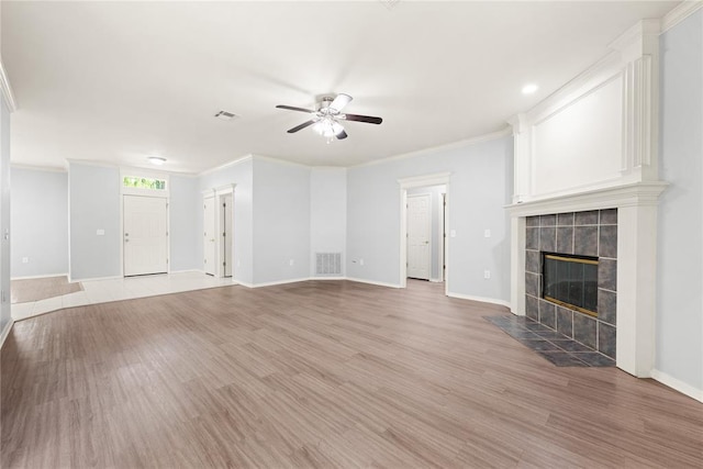 544 NW 172nd Pl Unit 8015998877, Edmond, OK 73012 - unfurnished living room with a ceiling fan, a tiled fireplace, light wood-style flooring, and crown molding