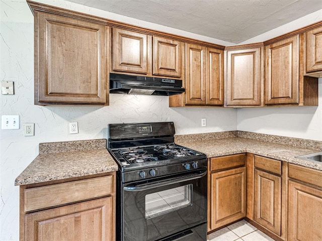6604 NW 32nd St, Bethany, OK 73008 - kitchen featuring black gas stove, under cabinet range hood, brown cabinetry, and light countertops