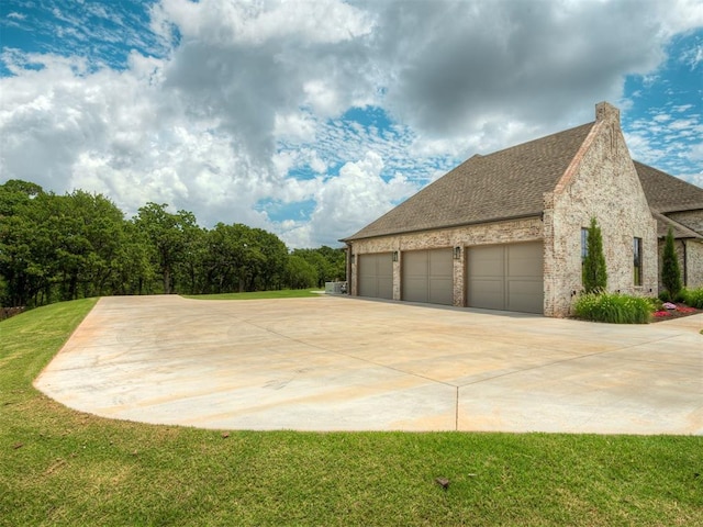 19890 Hickory Ridge Rd, Arcadia, OK 73007 - view of home's exterior featuring concrete driveway, a lawn, brick siding, a shingled roof, and an attached garage