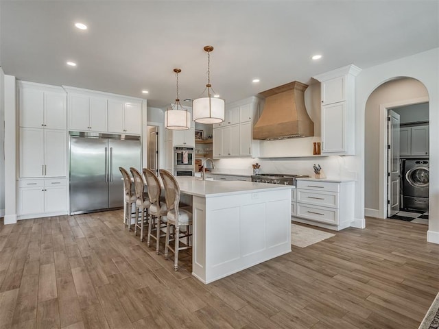 19890 Hickory Ridge Rd, Arcadia, OK 73007 - kitchen featuring custom exhaust hood, appliances with stainless steel finishes, light wood-type flooring, light countertops, and recessed lighting