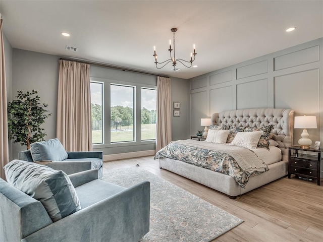 19890 Hickory Ridge Rd, Arcadia, OK 73007 - bedroom featuring a chandelier, a decorative wall, light wood finished floors, and recessed lighting