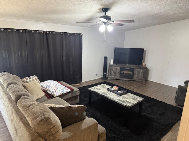 4620 SE 119th St, Oklahoma City, OK 73165 - living room featuring wood finished floors, a ceiling fan, a textured ceiling, a decorative wall, and ornamental molding