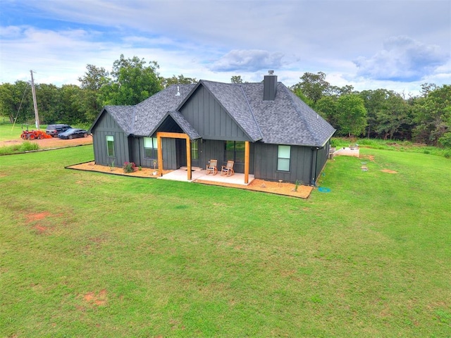 11275 S Henney Rd, Meridian, OK 73058 - back of house with board and batten siding, a chimney, a yard, and a shingled roof