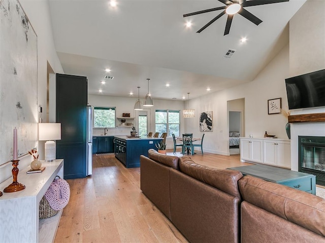 11275 S Henney Rd, Meridian, OK 73058 - living area with ceiling fan, light wood finished floors, a glass covered fireplace, recessed lighting, and high vaulted ceiling