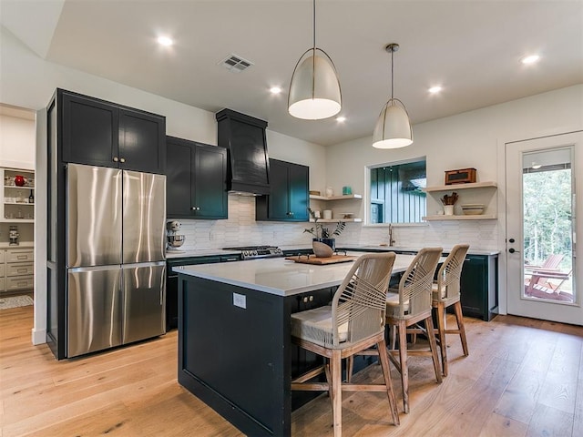 11275 S Henney Rd, Meridian, OK 73058 - kitchen with freestanding refrigerator, open shelves, custom exhaust hood, dark cabinetry, and a center island