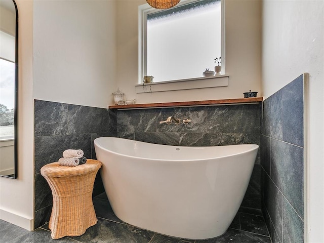 11275 S Henney Rd, Meridian, OK 73058 - bathroom with tile walls, a freestanding bath, a wainscoted wall, and tile patterned floors