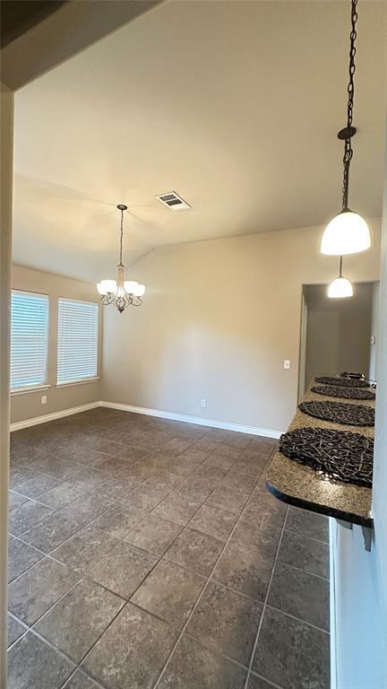 unfurnished dining area with a chandelier and lofted ceiling