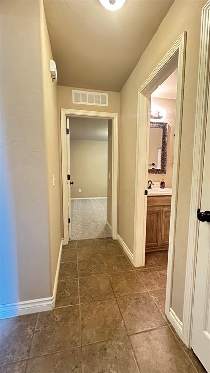 hall with baseboards and a sink