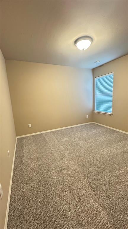 carpeted spare room featuring baseboards