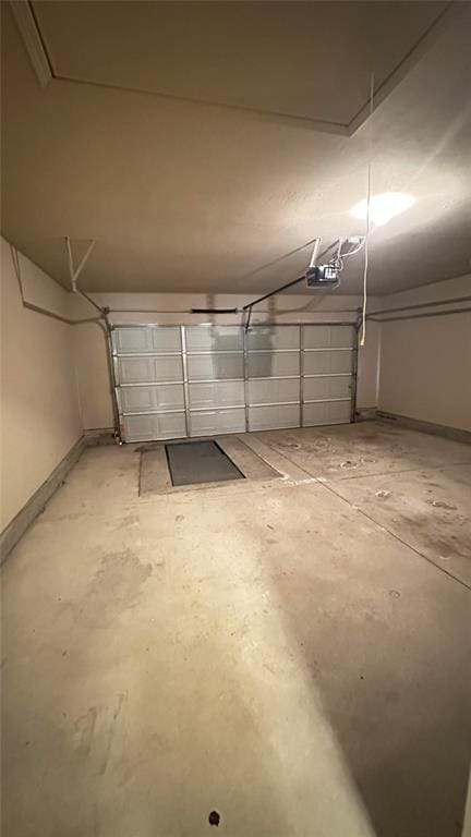 garage featuring a garage door opener and baseboards