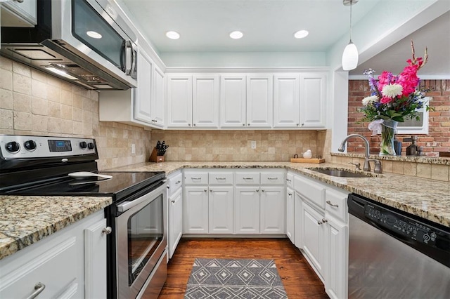 2633 Chaucer Dr, The Village, OK 73120 - kitchen with appliances with stainless steel finishes, dark wood finished floors, white cabinets, and hanging light fixtures
